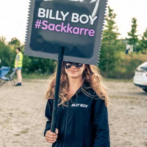 Billy Boy Autokino: Eine Promoterin hält ein Schild in die Luft auf dem Stht BILLY BOY #Sackkarre.