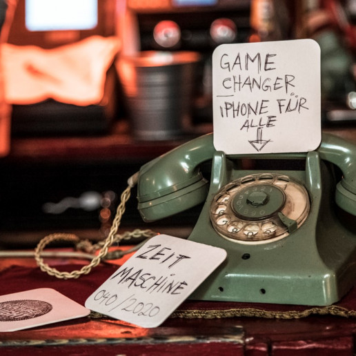 Daimler AG Leadership Nights: Ein altes grünes Telefon mit Wählscheibe an dem Bierdeckel lehnen, auf denen geschrieben steht, Gamechanger und Zeitmaschine