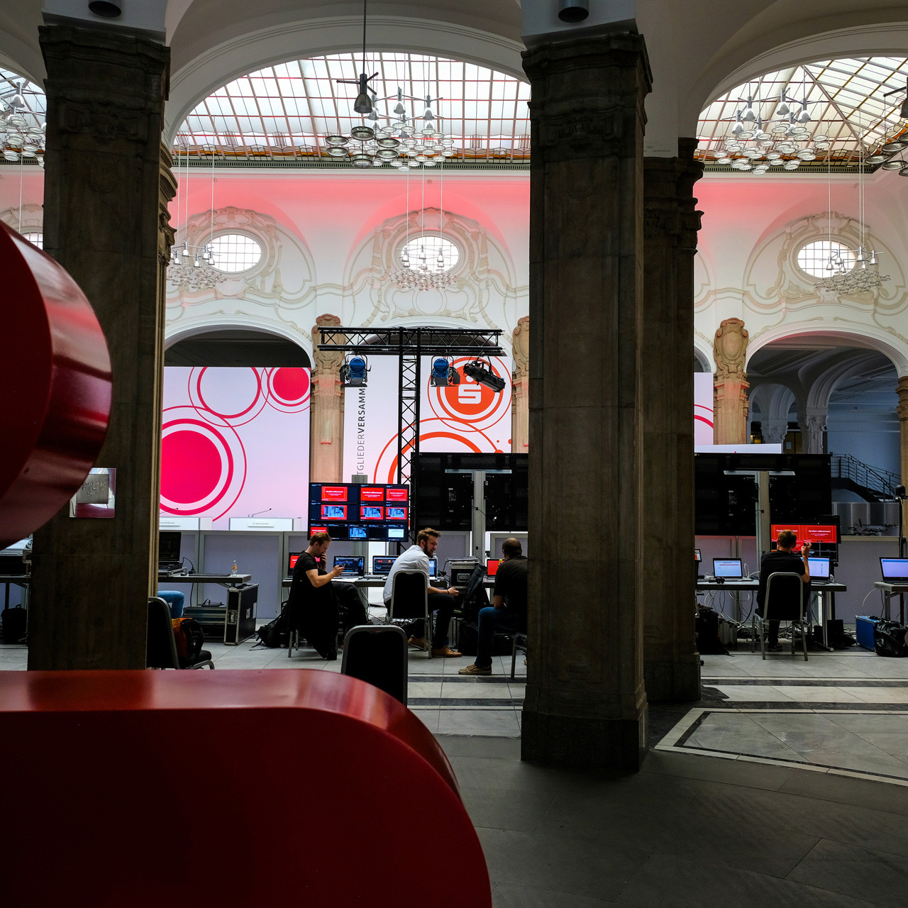 Die Sparkasse Bremen Mitgliederversammlung: Blick hinter die Kulissen, wo alle Techniker hinter ihren Tischen sitzen und arbeiten.