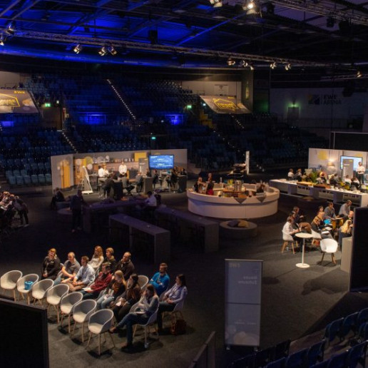 EWE Tel Partnerforum: Gesamtansicht der Workshopbereiche mit Teilnehmern. Die EWE Arena ist komplett dunkel, nur die Workshopbereiche sind erhellt.