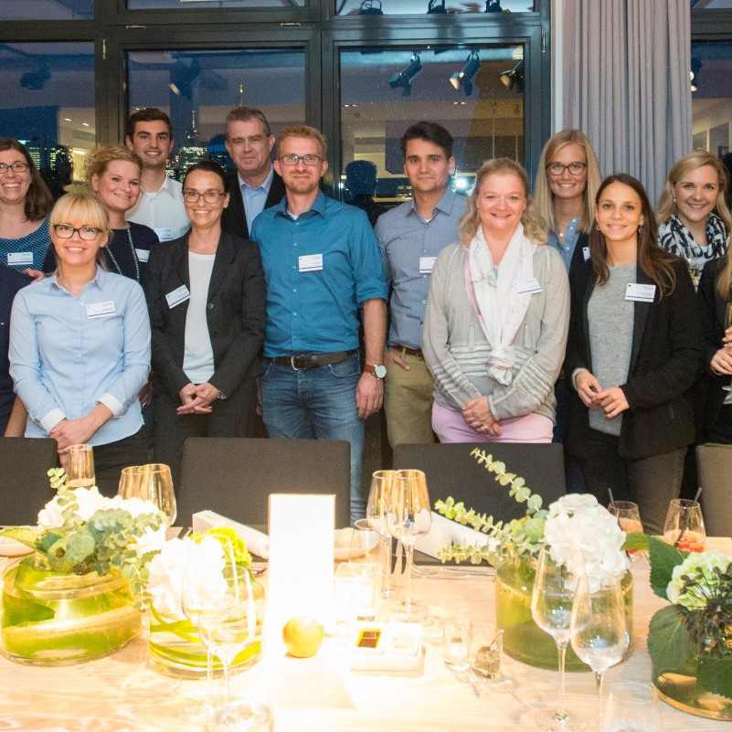 Faurecia Messe: Gruppenbild des Messestandpersonals vor einer eingedeckten Tafel im Restaurant.