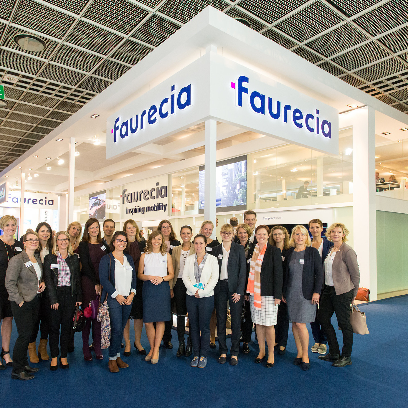 Faurecia Messe:Gruppenbild in der Messehalle mit allen Mitarbeitern vor dem Messestand.