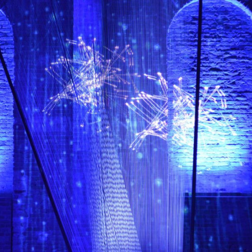 Fraunhofer Jahrestagung: Von der Decke bis auf die Bühne sind Fäden gespannt, auf diese Fäden sind Logos projeziert.