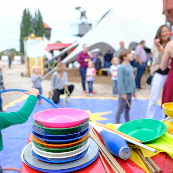 OLB 150 Jahre Festival: Bei ener Mitmachaktion für Kinder stehen gaz viele Plastikteller übereinander gestapelt. Mit diesen Tellern kann man auf einem Stock jonglieren.