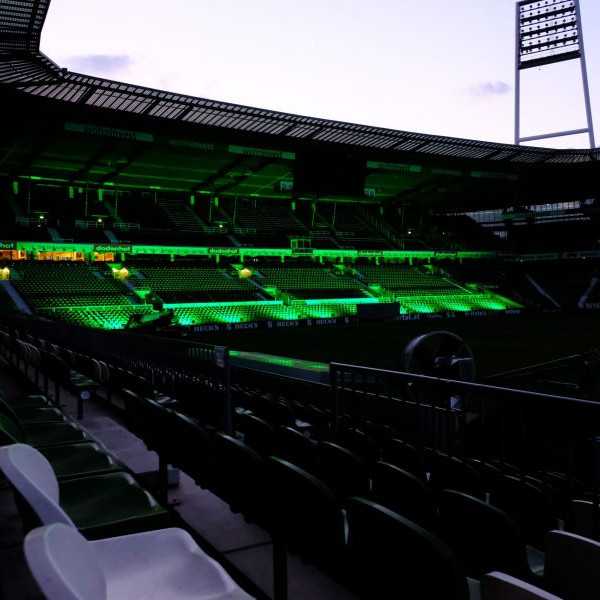 Werder Opening Weekend: Blick in leere wohninvest Weserstadion. Die Westkurve ist grün beleuchtet.