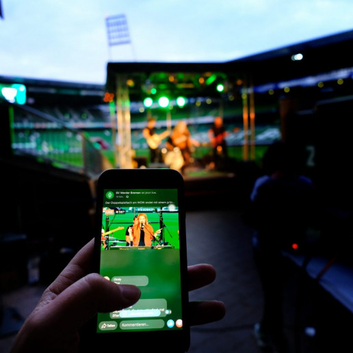 Werder Opening Weekend: Blick auf das Livebild eines Handys auf dem Lenna und Band zu sehen sind.